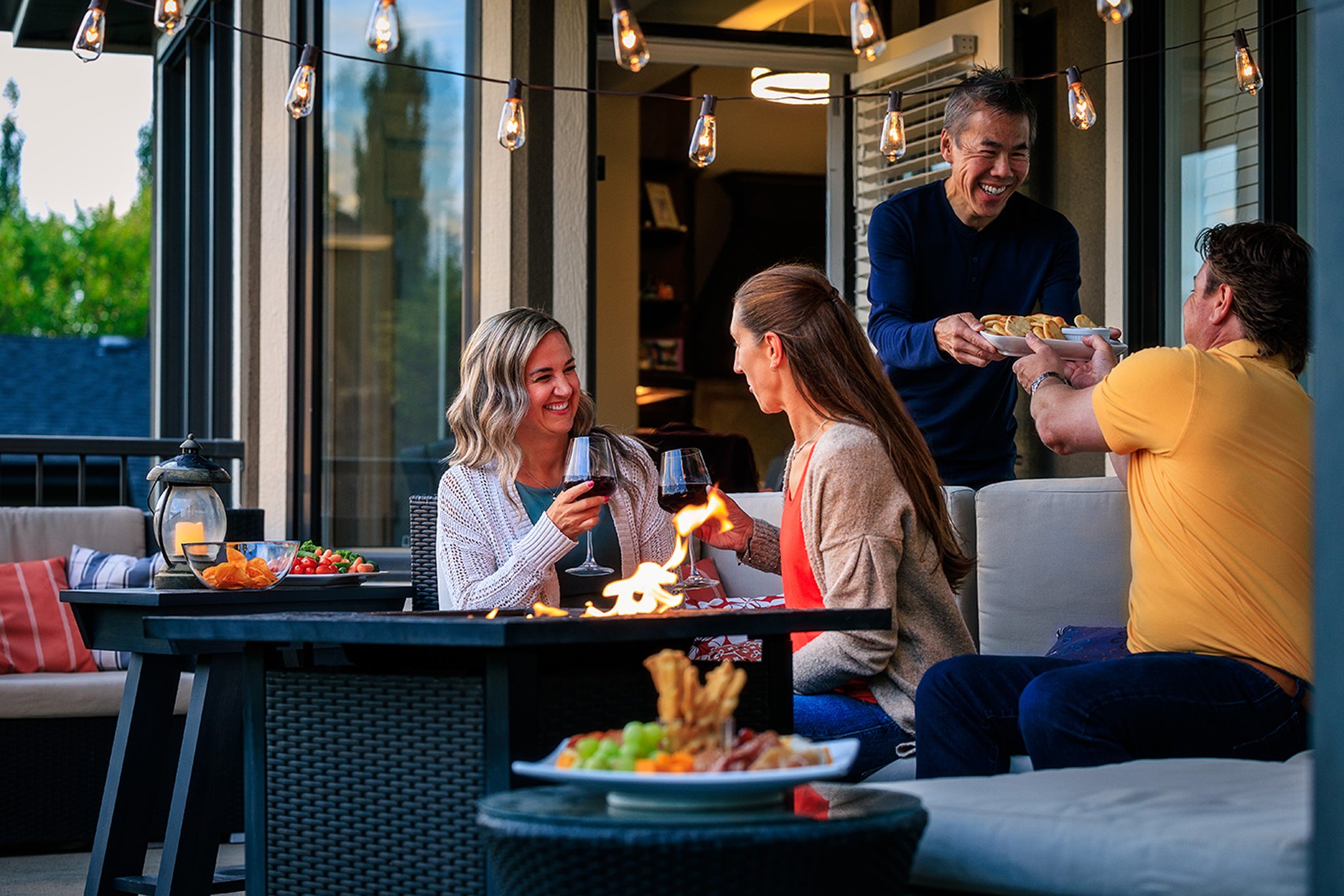 Neighbours sharing a meal on a deck at home