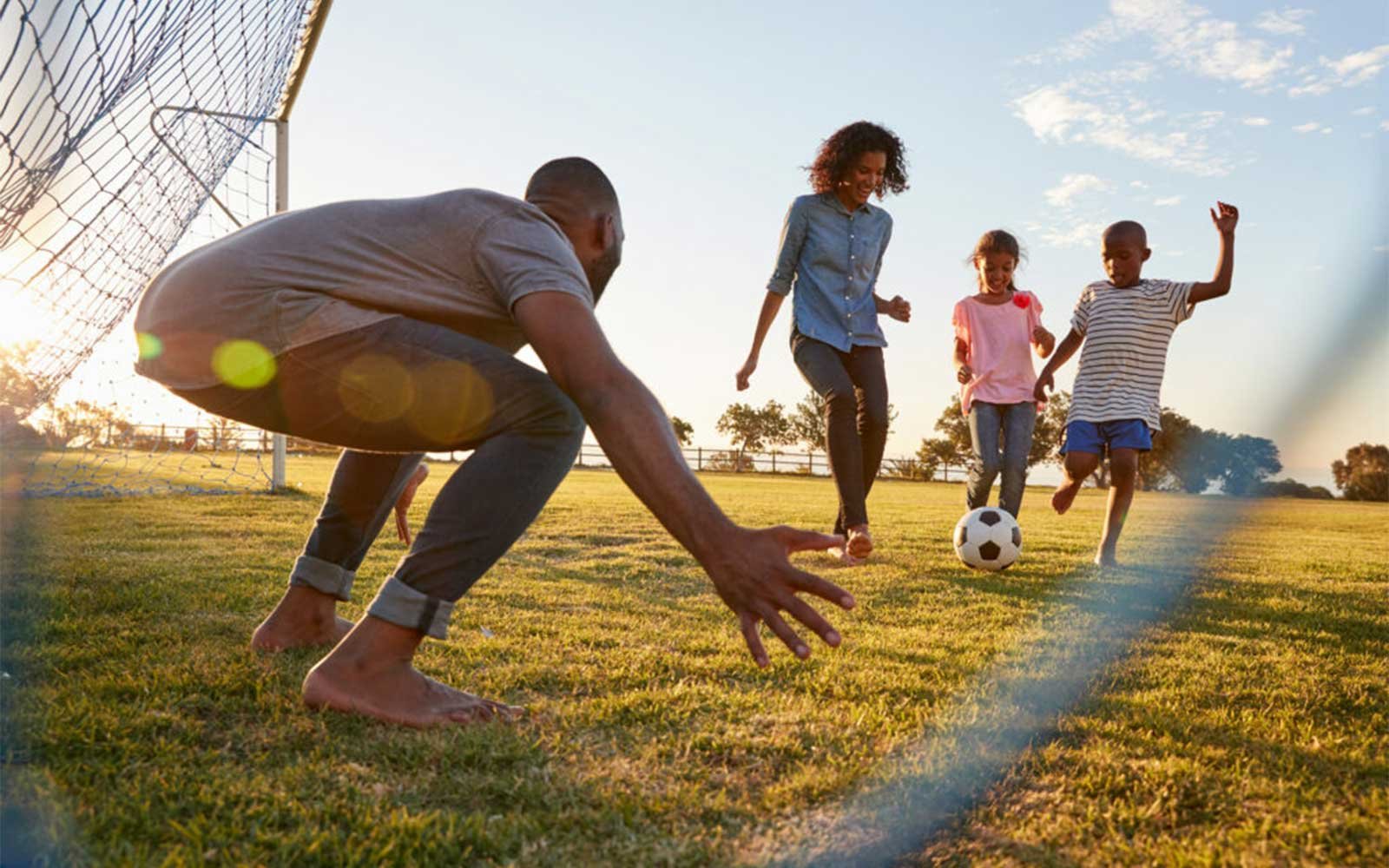 A family playing soccer in the park in Creekstone