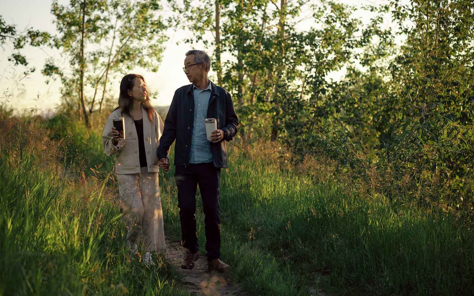 Couple walking hand in hand on a trail near Crown Park
