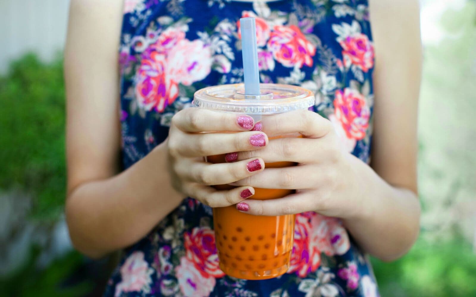 Women in floral shirt holding boba