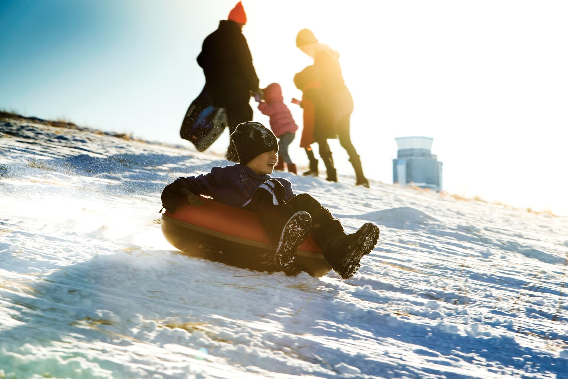 Lifestyle photo of kids tubing at Central Park in Denver CO.