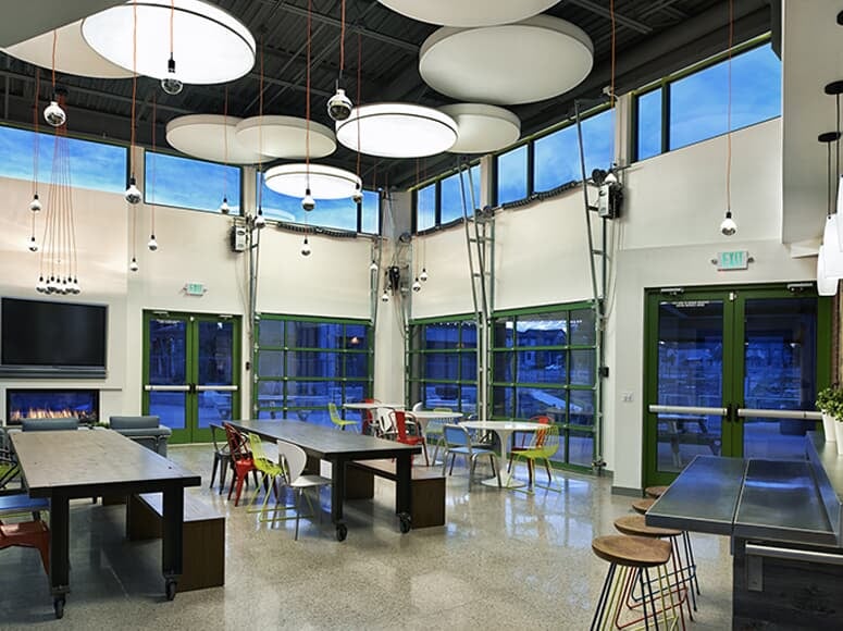 Tables and chairs with funky light fixtures inside The Shed at Midtown in Denver, CO