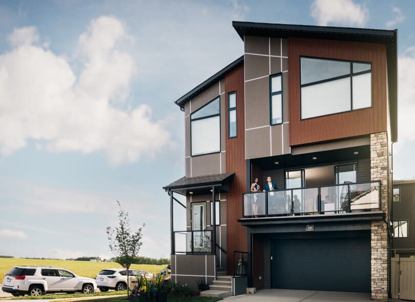 Couple enjoying cocktails on the balcony of the Newport in the Cali Collection in Edmonton, AB