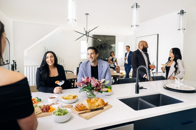 Friends enjoying cocktails and appetizers in the Newport in the Cali Collection at The Orchards in Edmonton, AB