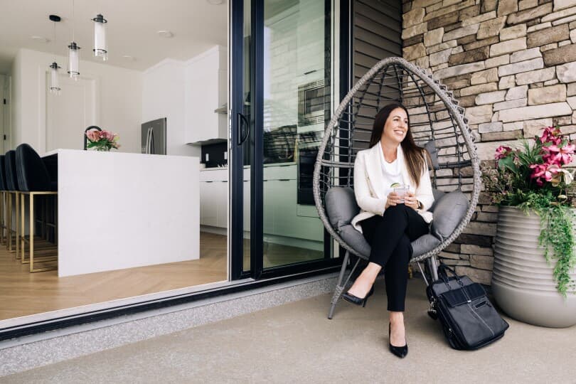 Woman enjoying a cocktail on the balcony of the Newport in the Cali Collection in Edmonton, AB