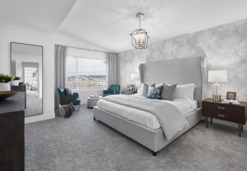 Primary bedroom with wallpaper and sitting area in Asher at The Orchards in Edmonton, AB