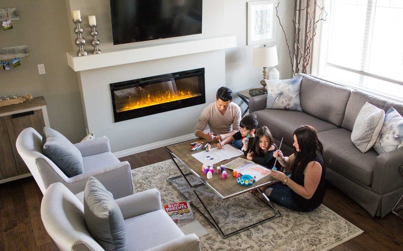 Family in front of a fireplace The Orchards Community