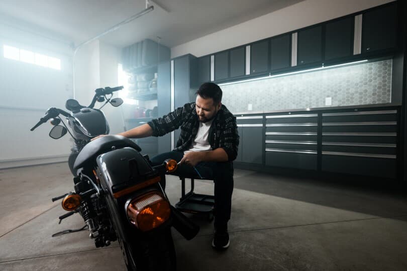 Man working on his motorcycle in the garage of his Brookfield Residential home in Edmonton, AB