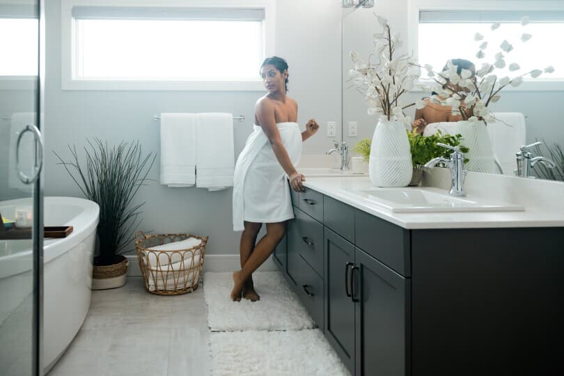 Woman in a towel in the elegant ensuite of her Brookfield Residential home in Edmonton, AB