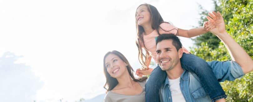 Family of three with the little girl on her dad's shoulders