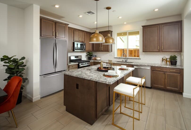 Kitchen with dark wood cabinets and island in Residence 4 at Chandler in Brentwood, CA