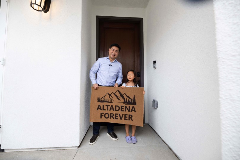 The Kang family in front of their new home with a welcome mat