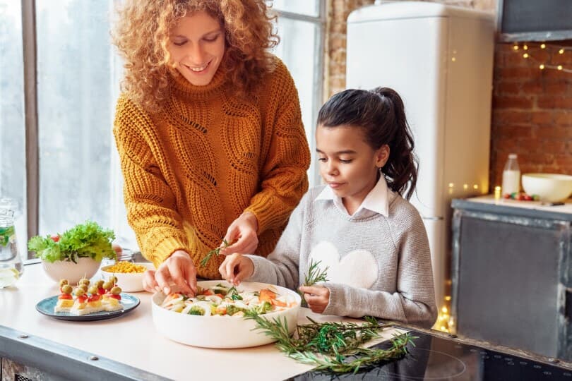 Mother and daughter cooking together in a kitchen