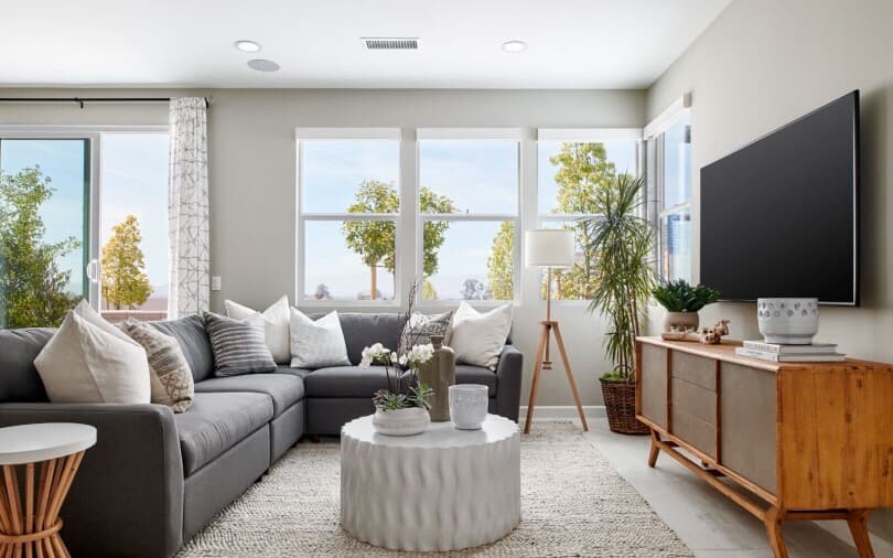 Living area with sectional and TV in Indigo Plan 3 at New Haven by Brookfield Residential in Ontario Ranch CA