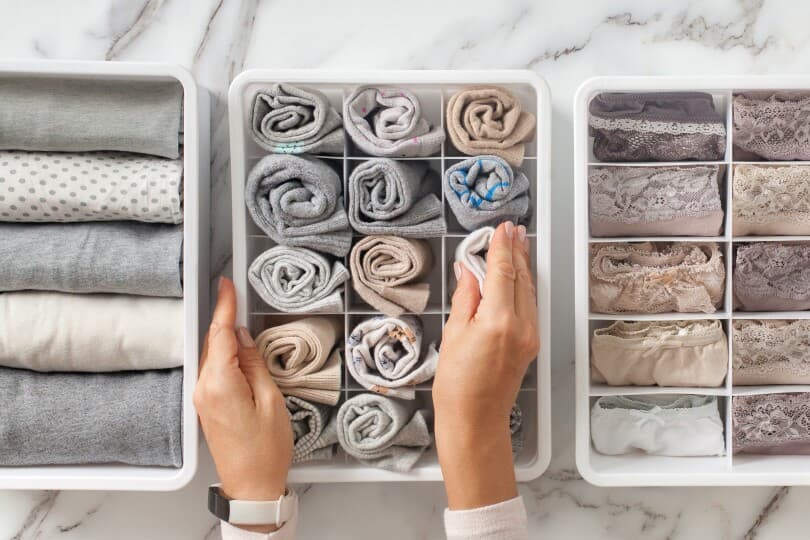 Hands organizing a sock drawer