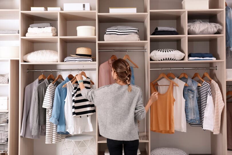 Woman organizing clothing in a closet