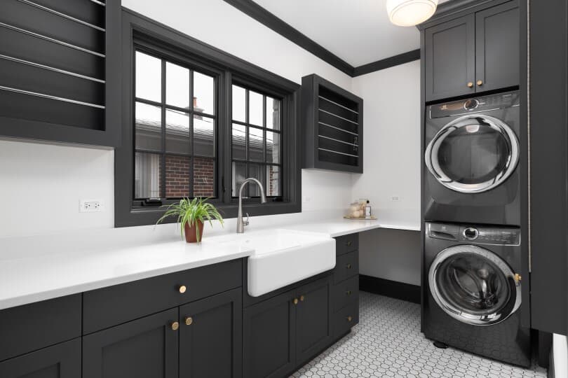 Laundry room with dark grey cabinets, farmhouse sink, and marble countertops