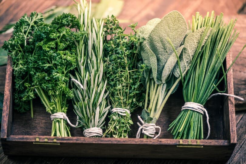 Fresh herbs tied in bunches with twine in a wooden box