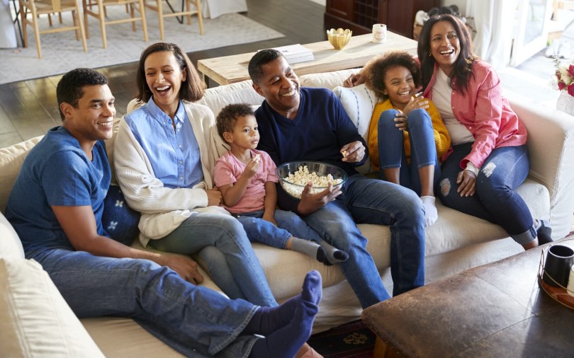 Multi generational family relaxing and laughing together on a couch