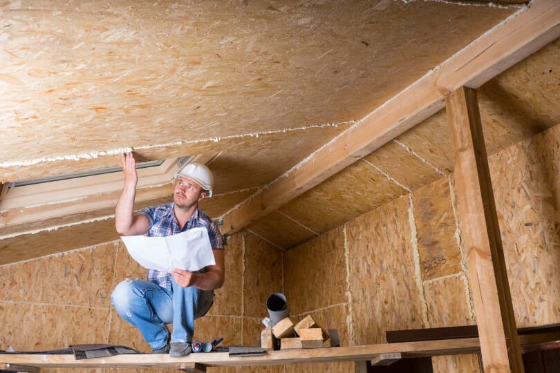 Man inspecting the attic for issues