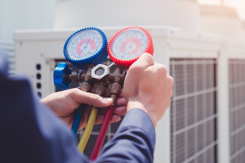 Technician using gauges to check an air conditioner