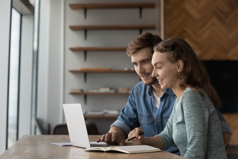 Young couple researching on a laptop in a home