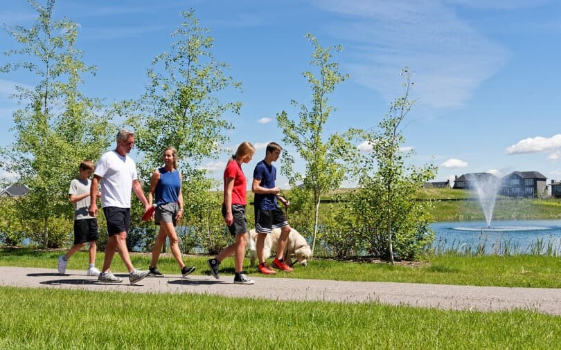 Family walking their dog at Artesia in Heritage Pointe in Calgary AB