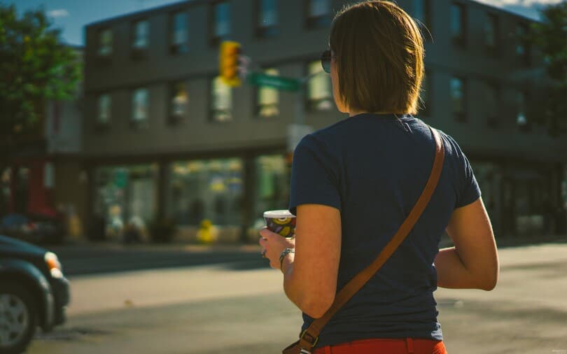 Woman walking with coffee in Whitby ON