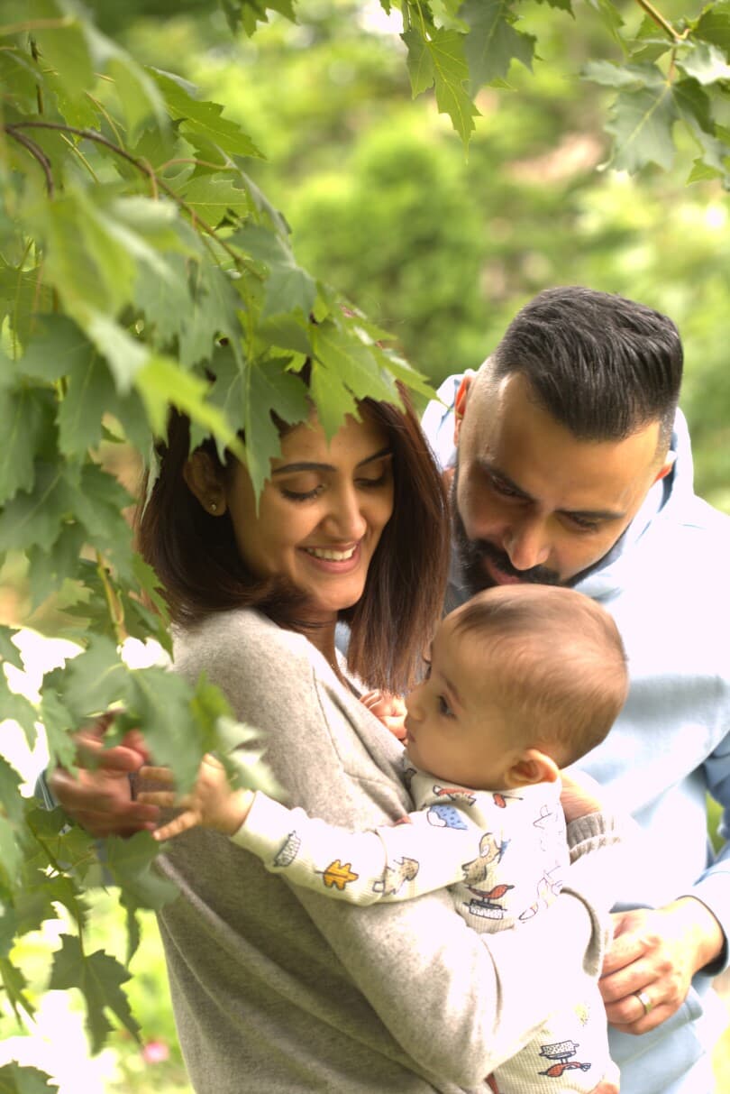 Couple snuggling their baby out in nature in Midhurst, ON