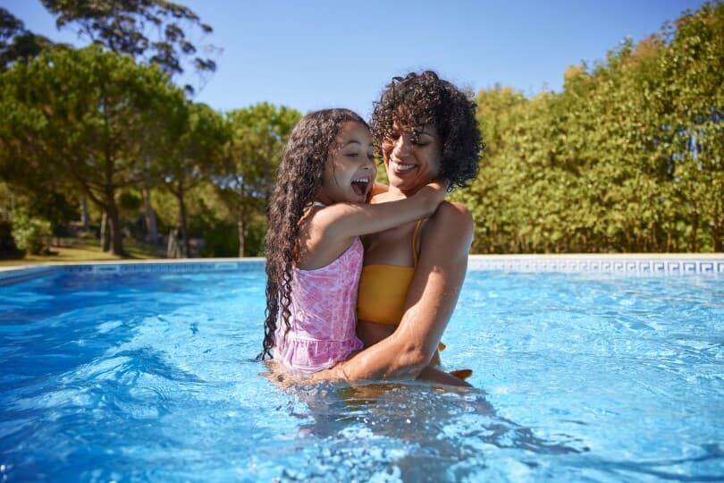 Mother and daughter playing in a pool