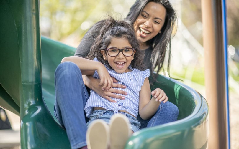 Mother and daughter on a playground slide at Wendell Falls in Wendell NC