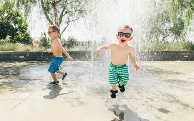 Two little boys playing in the water at a splash pad at New Haven in Ontario Ranch CA