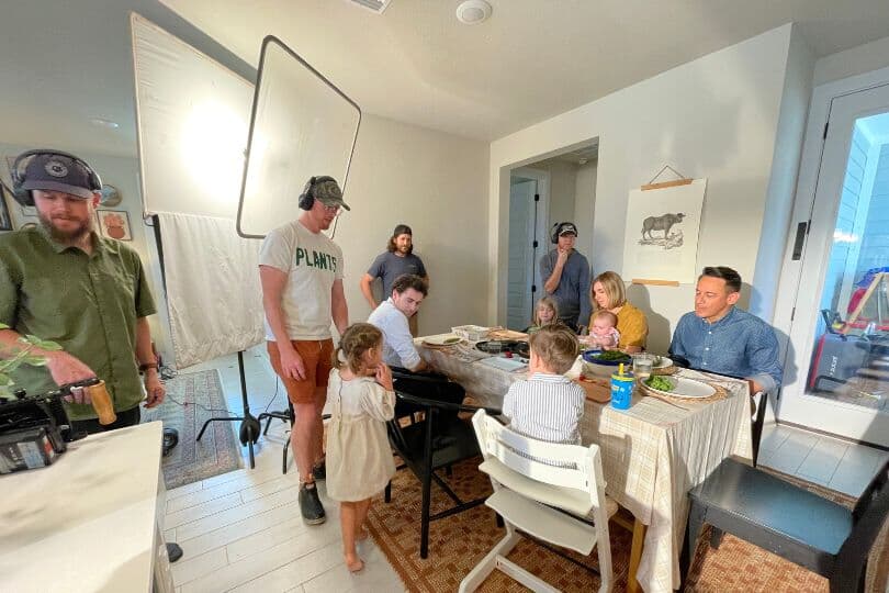 Commercial crew and family at dining table behind the scenes