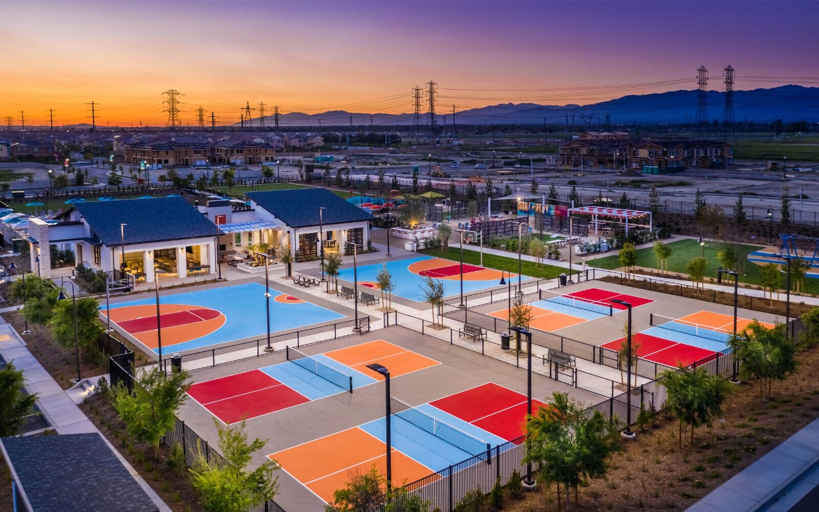 Ariel view of colorful basketball and pickle ball courts at dusk in Canvas Park at New Haven in Ontario Ranch, CA
