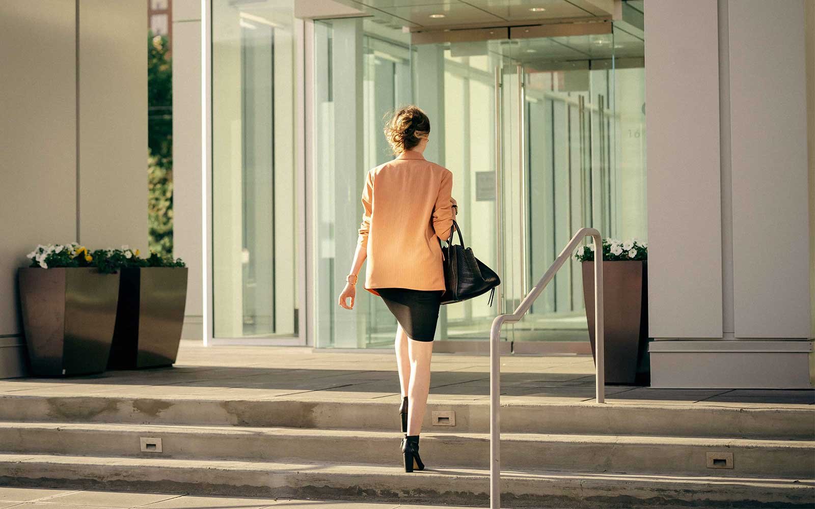 A woman walking into an office building in downtown Calgary