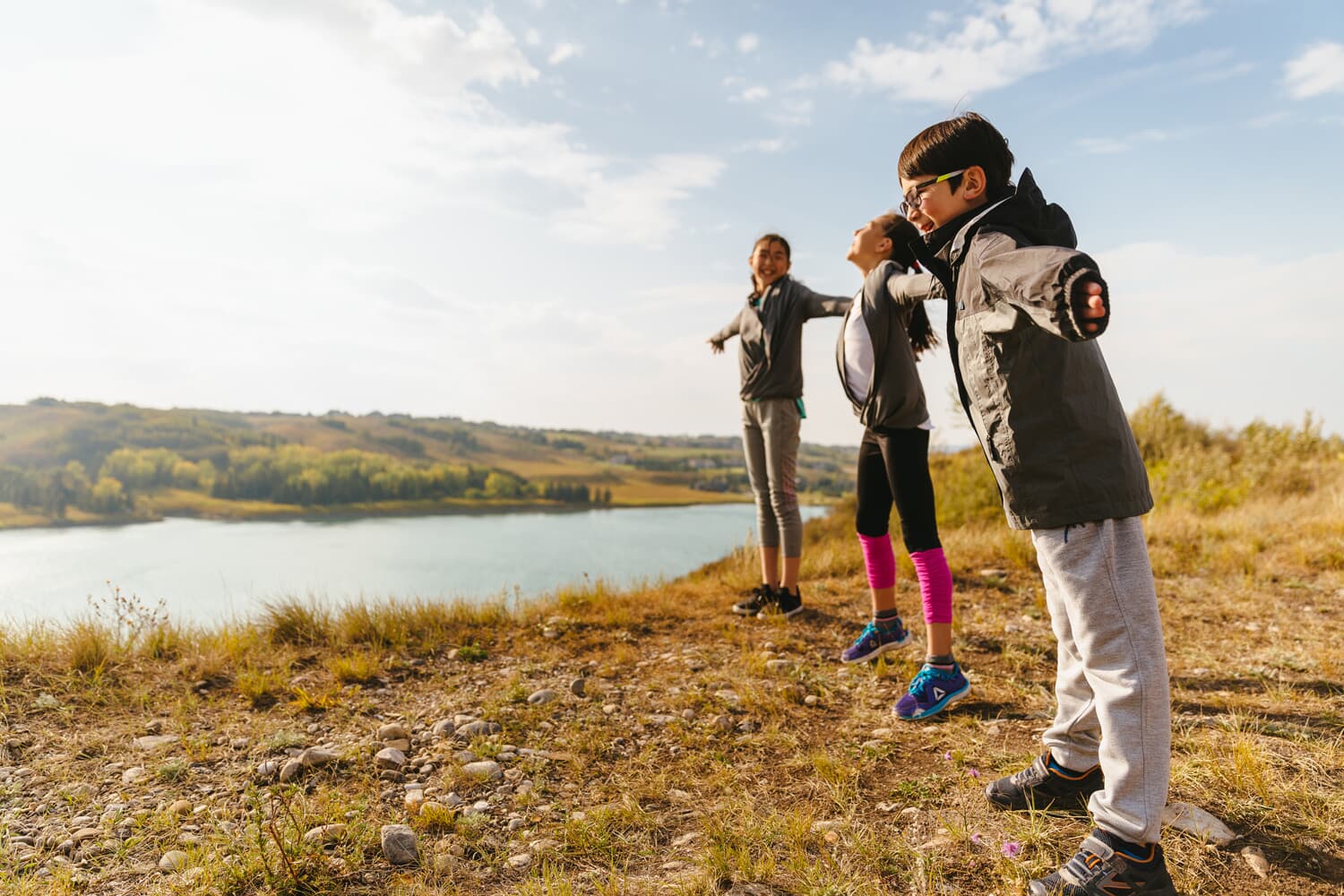 A family walking by the river located in Rockland Park in Calgary.
