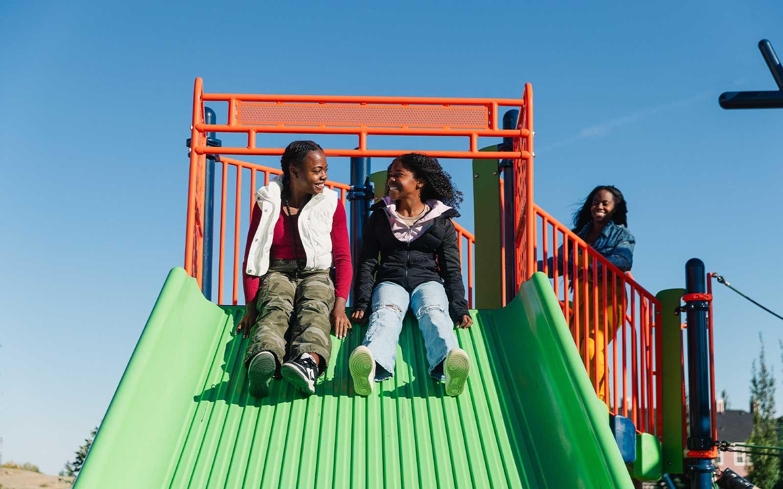 Two kids enjoying a slide at the Silver Spruce community playground