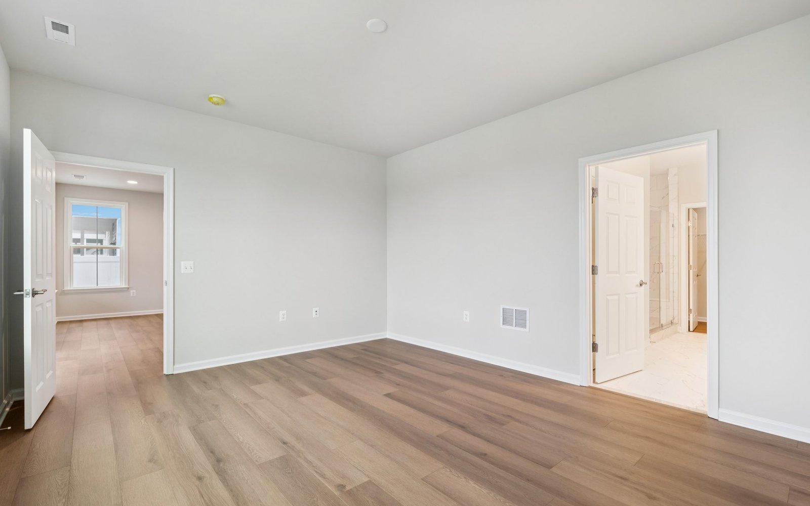The main level primary bedroom in a Fitzgerald garden home at Hiatt Pointe at Snowden Bridge.
