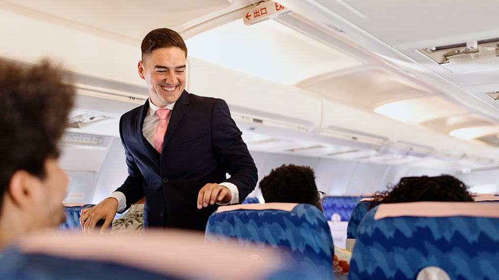 Flight attendant checking on the passengers before take off