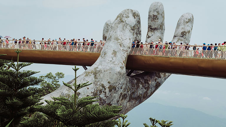 Visitors walk across the Golden Bridge, supported by giant stone hands, at Ba Na Hills near Da Nang, Vietnam.