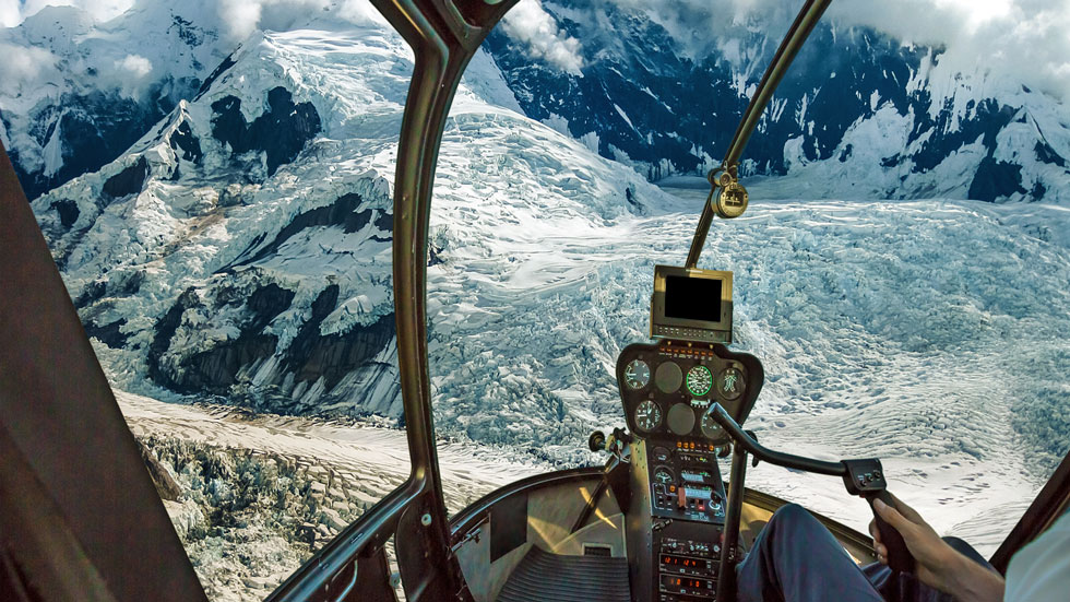 Helicopter cockpit view over Denali National Park glaciers, Alaska. Photo by bennymarty/iStock.com