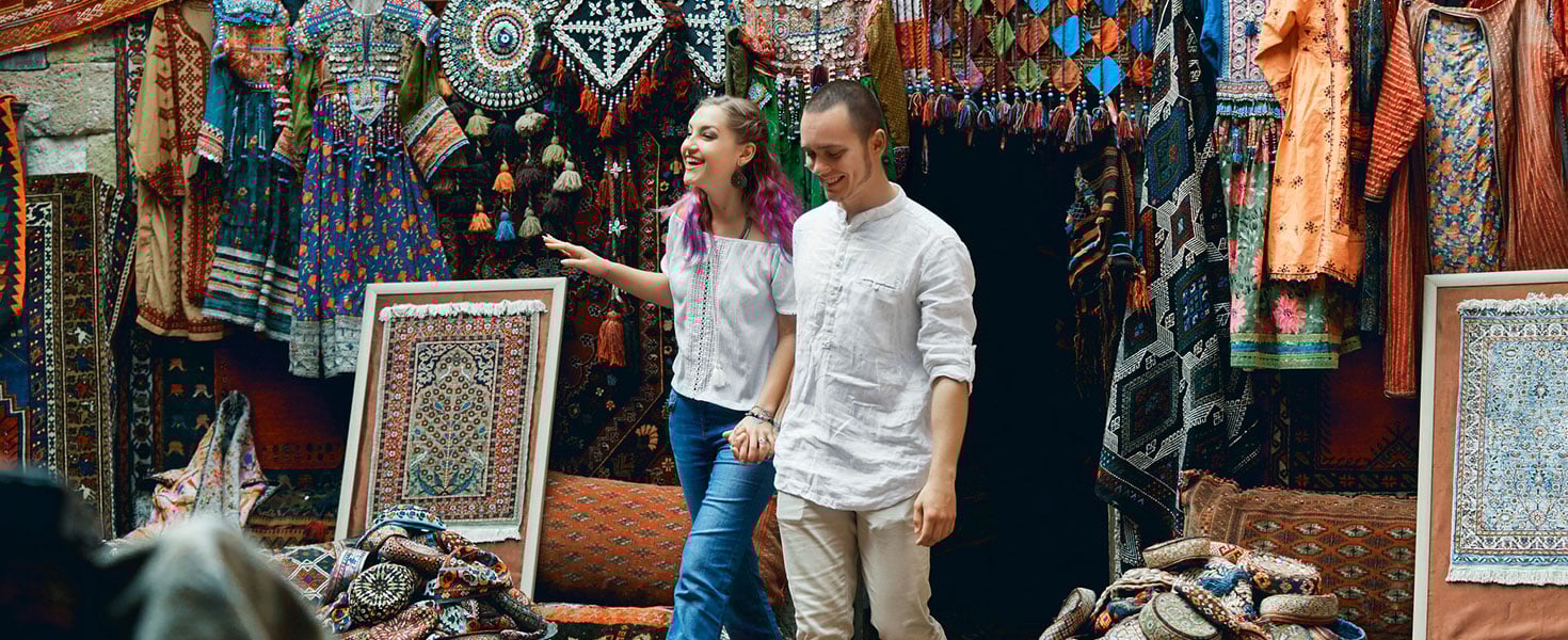 Couple in love walks and hugs at the Eastern carpet market. A man and a woman choose a Turkish carpet. Photo by angel_nt