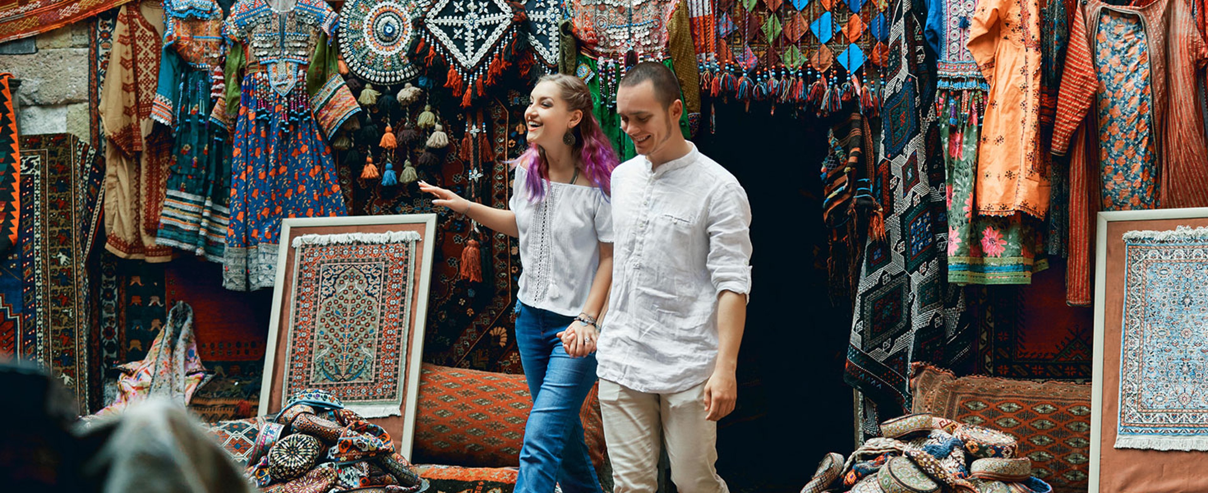 Couple in love walks and hugs at the Eastern carpet market. A man and a woman choose a Turkish carpet. Photo by angel_nt