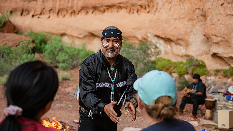 Guests listening to Navajo storytelling around a campfire in the Southwest desert