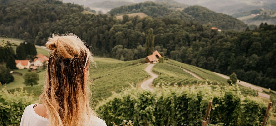 girl looking out at field and hills