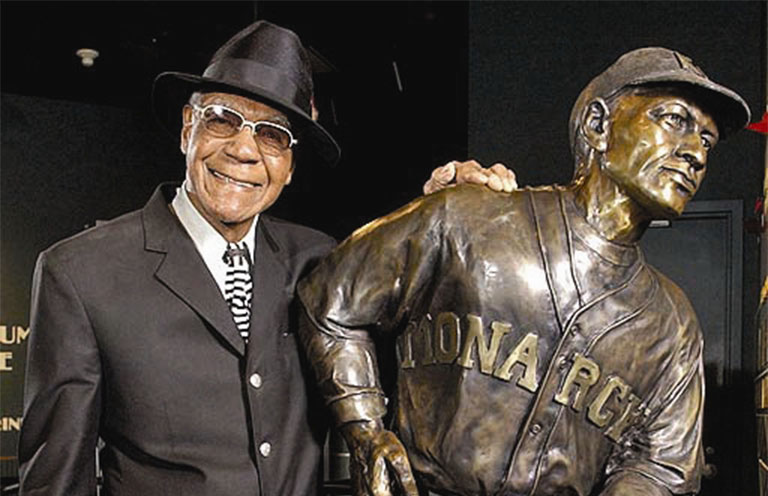 Buck O’Neil stands beside a statue