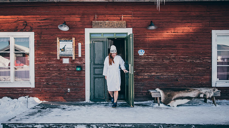 A guest exits the daylight sauna at Icehotel in Jukkasjärvi, Sweden, before an Arctic cold plunge.