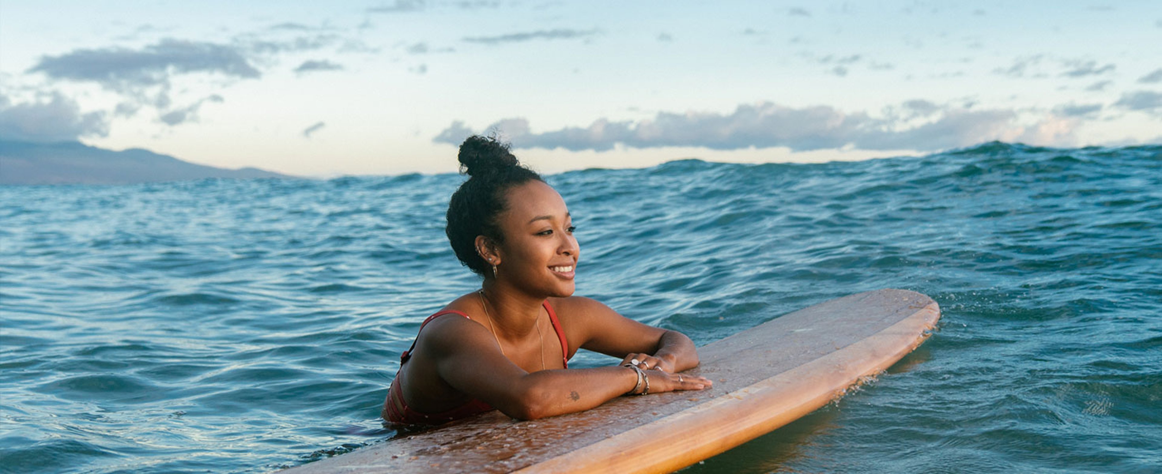 Woman in the ocean on her surfboard in Hawaii