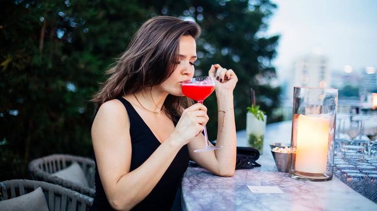 woman drinking cocktail at rooftop bar