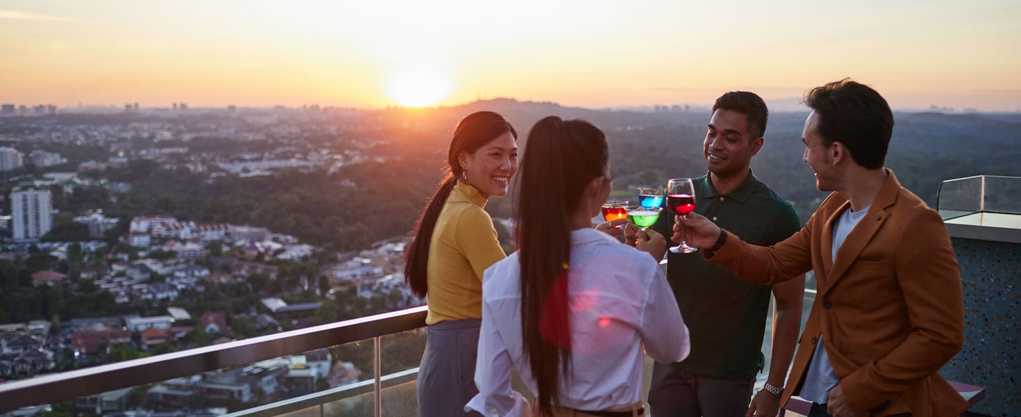 group of friends toasting at a rooftop bar